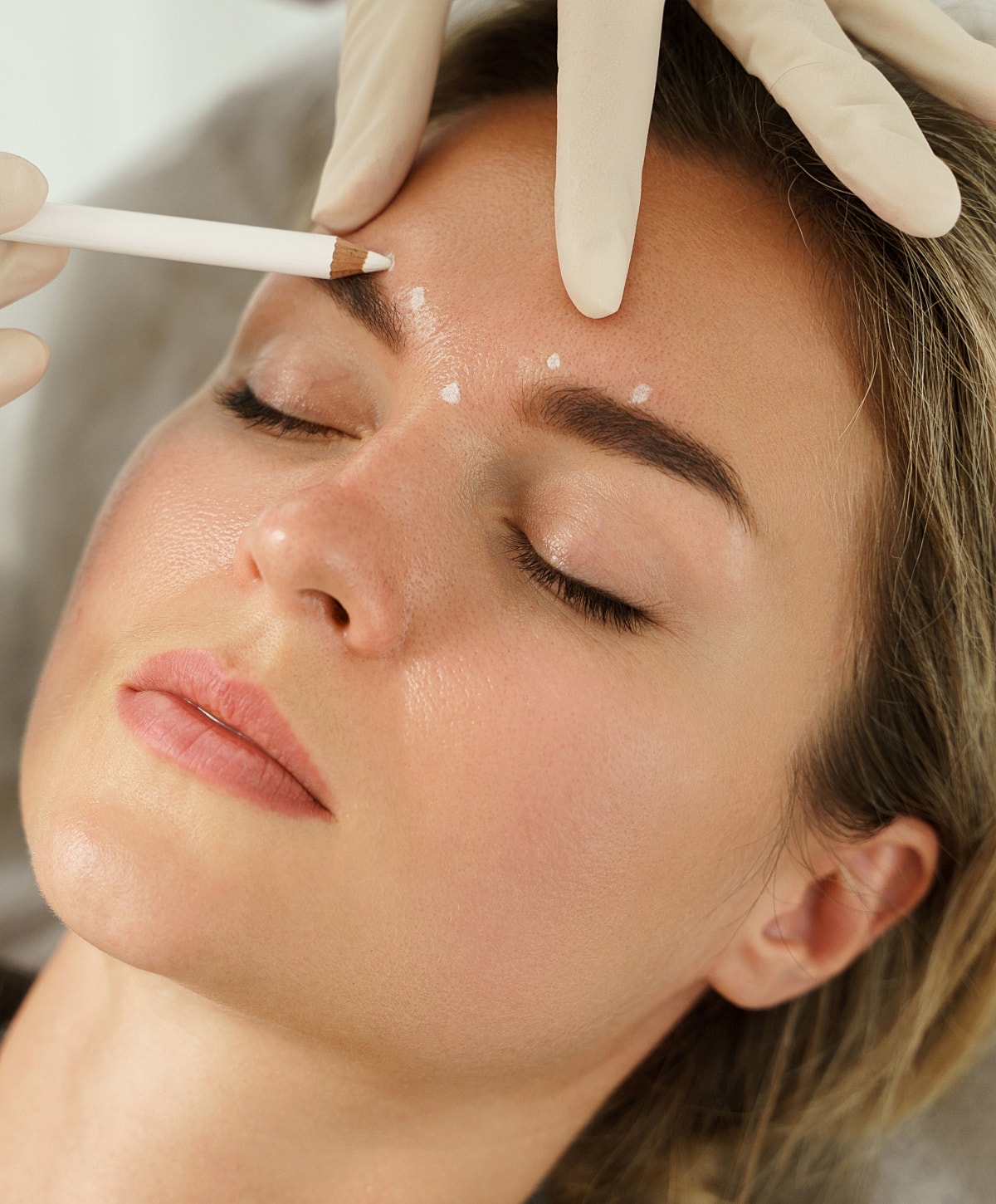 Facial treatment with pencil and gloved hands.