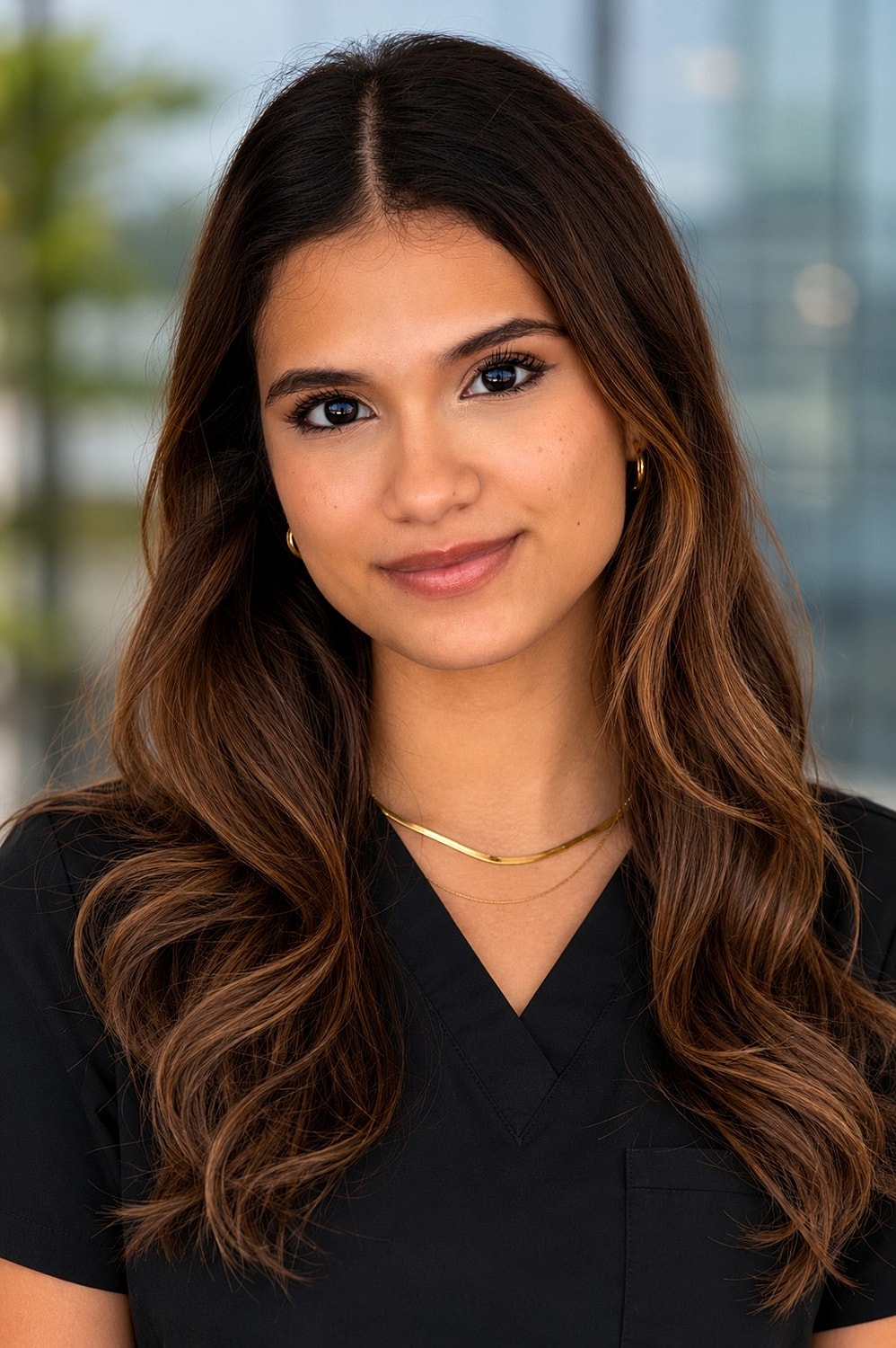 Young woman in professional attire, smiling warmly.