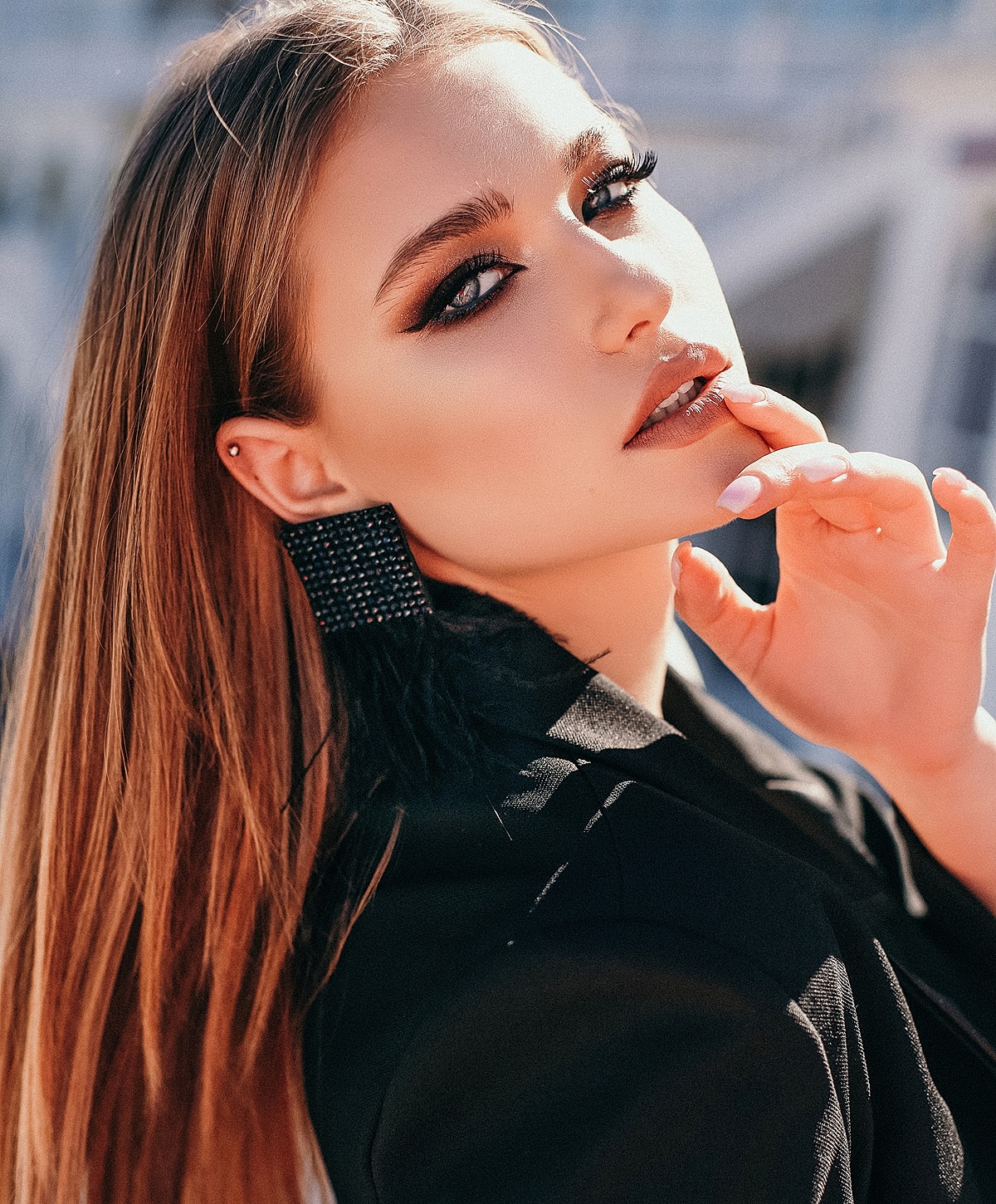 Stylish woman with striking makeup and accessories.