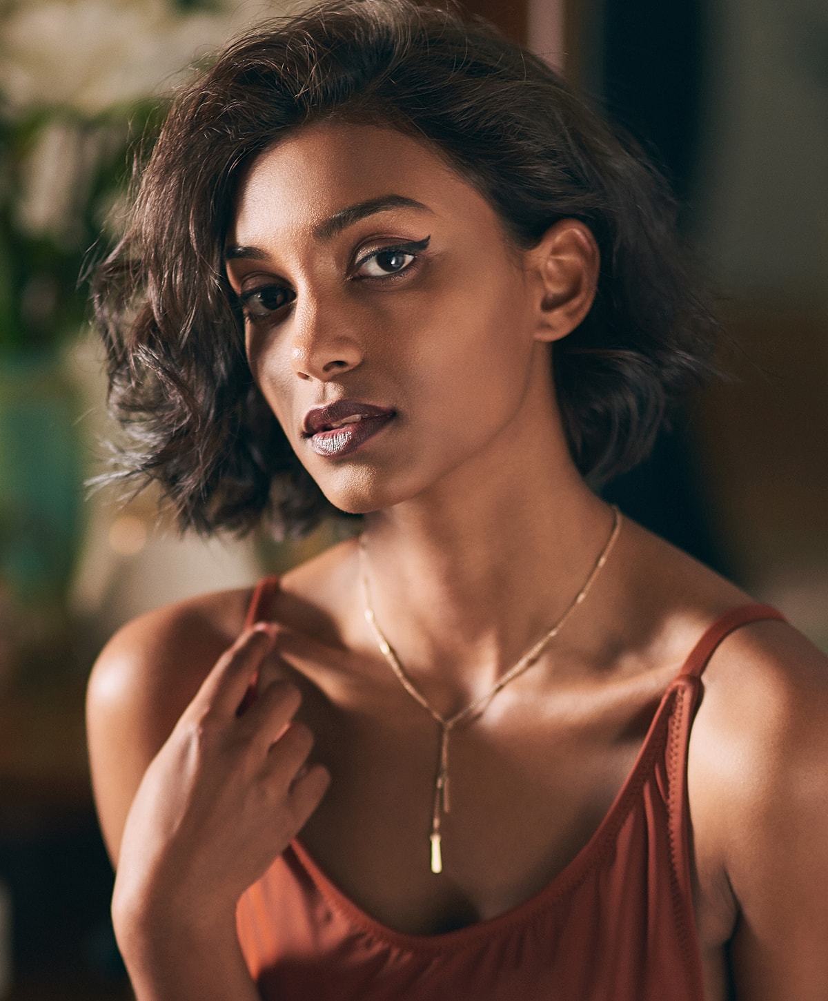 Woman with curly hair and striking makeup.
