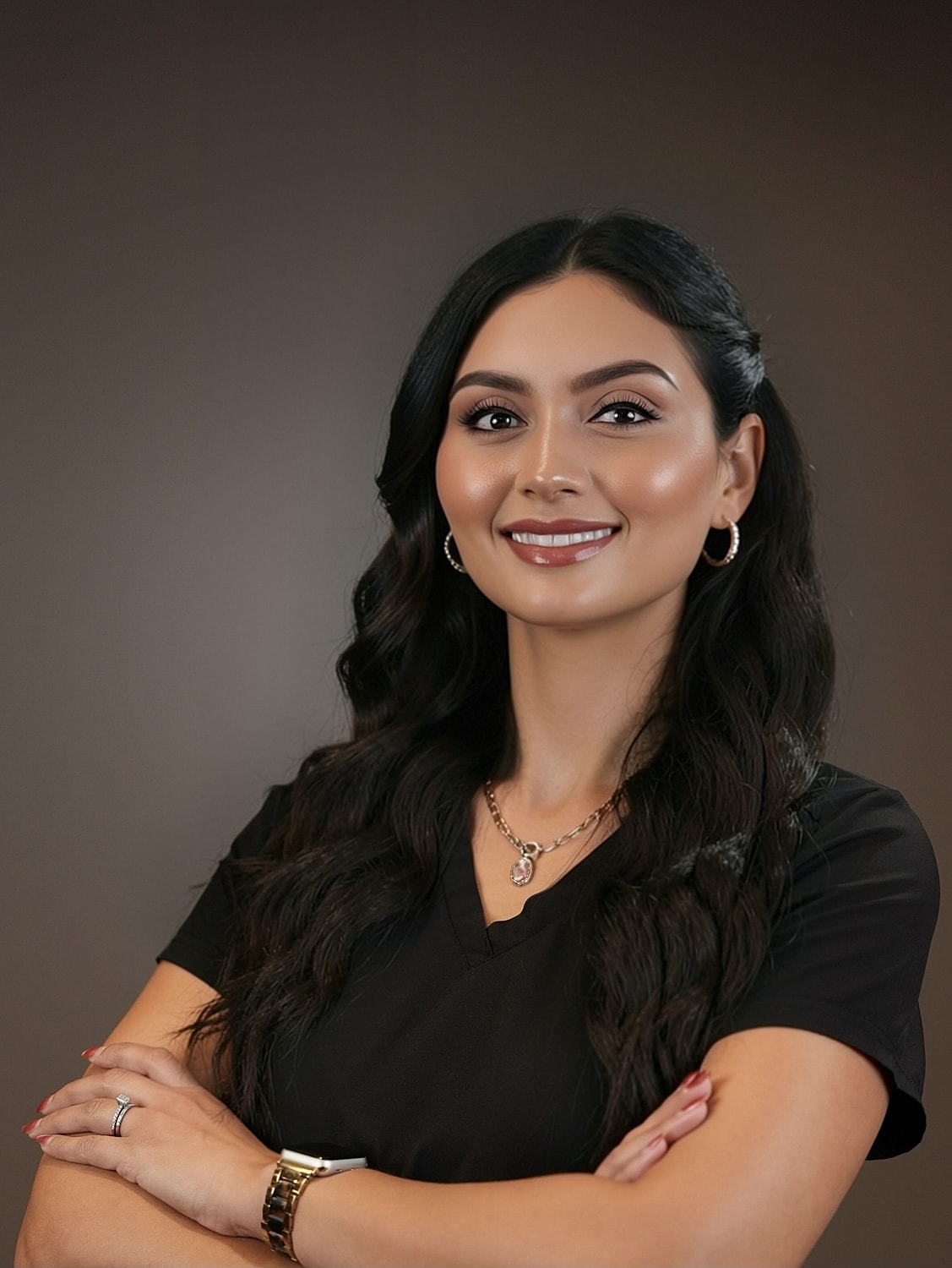 Smiling woman in professional attire with crossed arms.